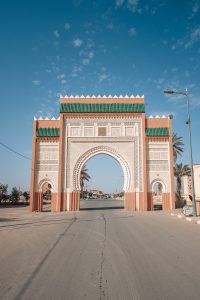 a large white arch with a sky background